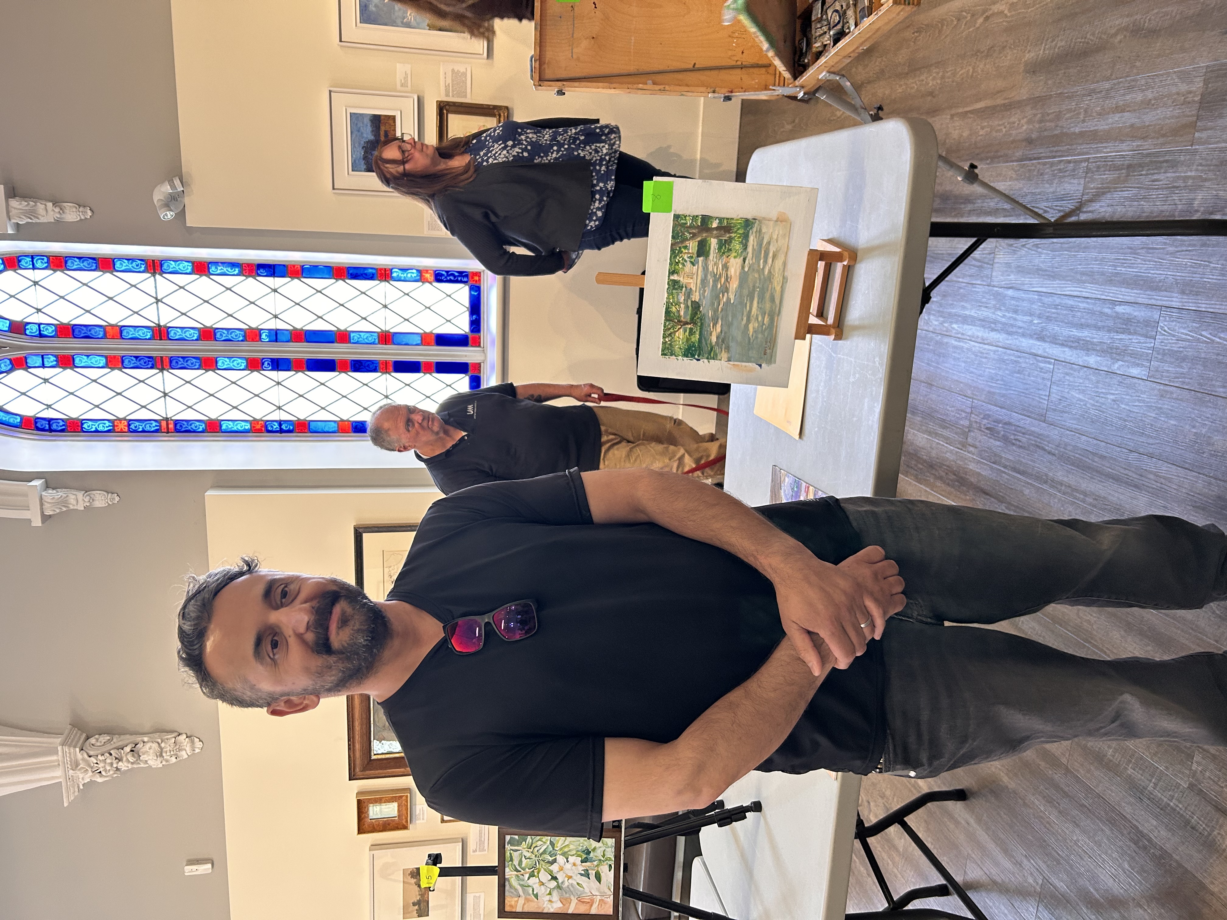 A man smiling while holding a painting