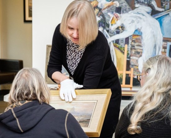 gallery curator showing artwork