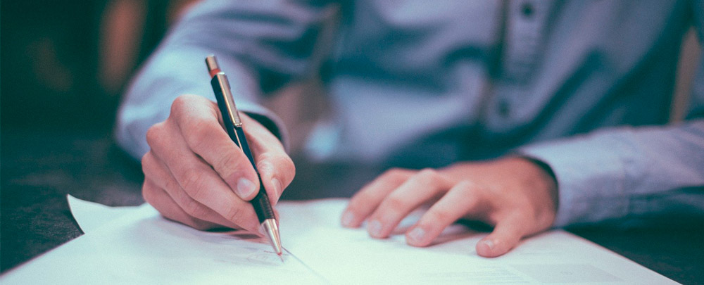 man signing a document