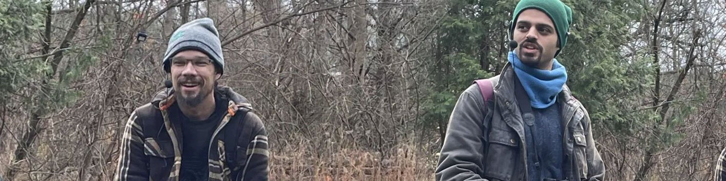 Two men in the forest wearing fall clothing