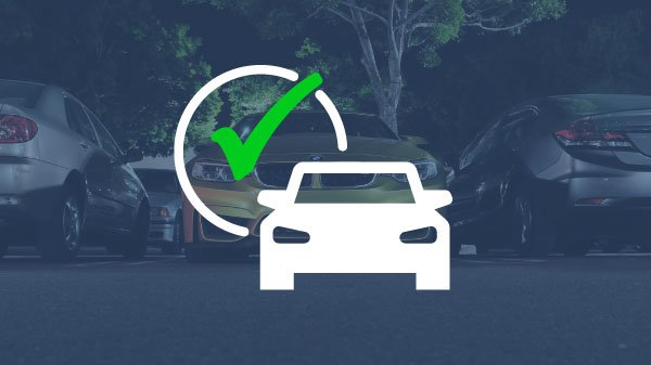 Car parked at night with green checkmark