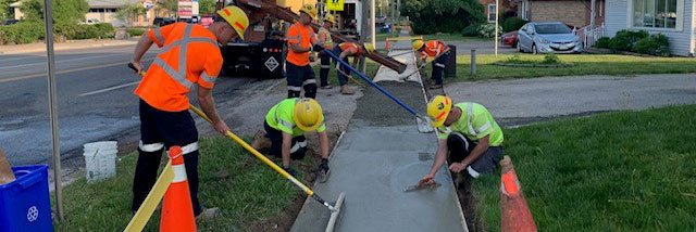 Public Works staff working on a sidewalk