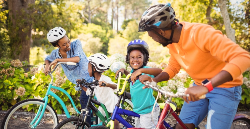 a family of four on bikes in a park with trails