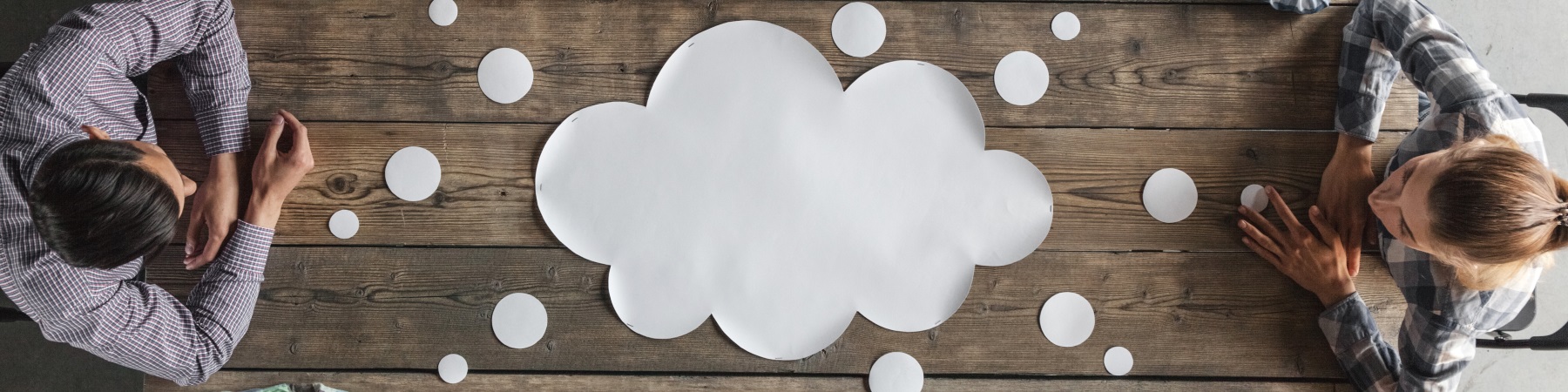 speech bubble in the middle of table with people around it