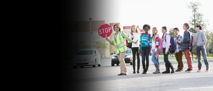 Crossing guard leading children to cross safely